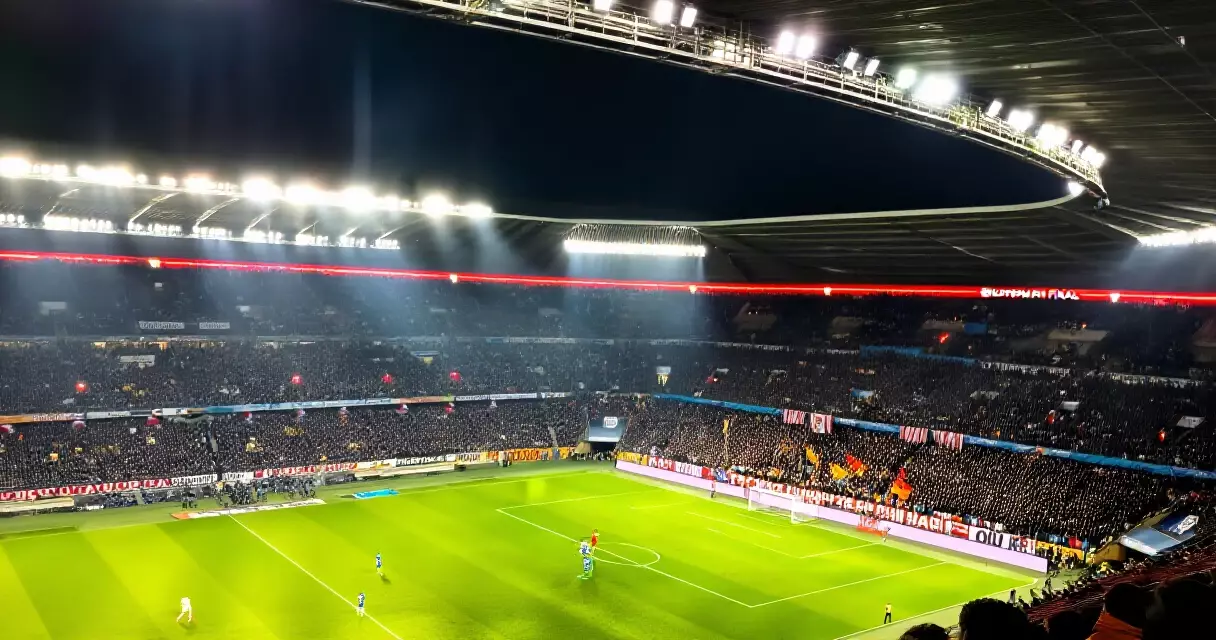 Floodlit stadium packed with fans during a Champions League final at night