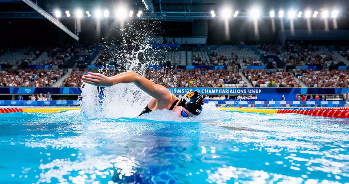 Competitive swimmer diving into pool lane at international championship meet