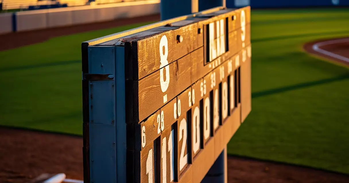 Minor league baseball scoreboard at dusk with warm sunset light