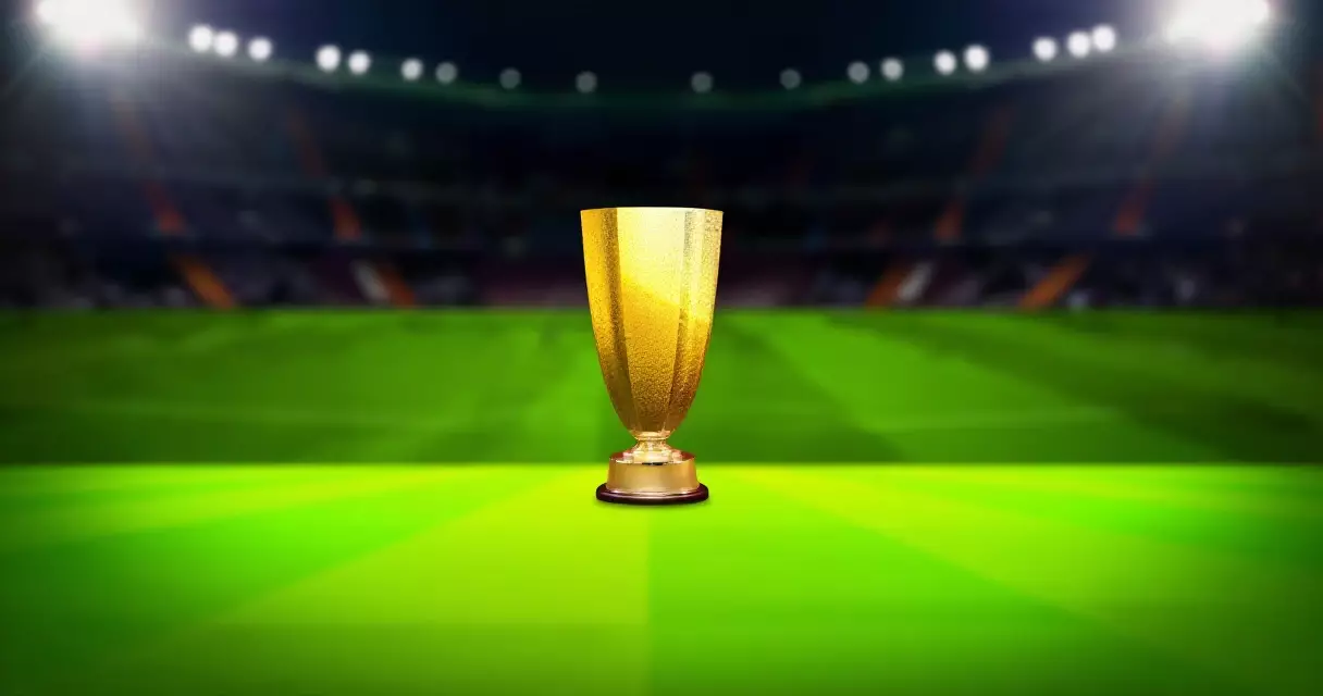 Premier League trophy on the pitch under floodlights