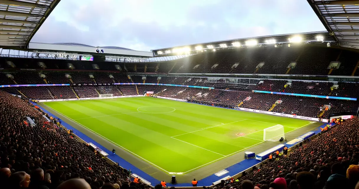 Premier League stadium filled with fans on a weekend matchday, aerial view