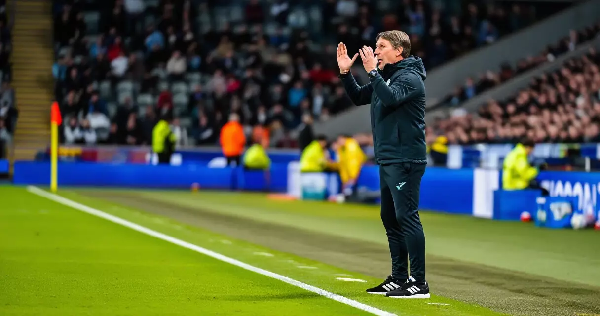 Football manager directing players from the touchline during a top-level match