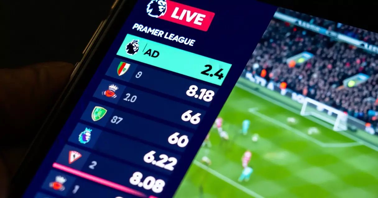 Smartphone showing live Premier League match score from a real-time API data feed