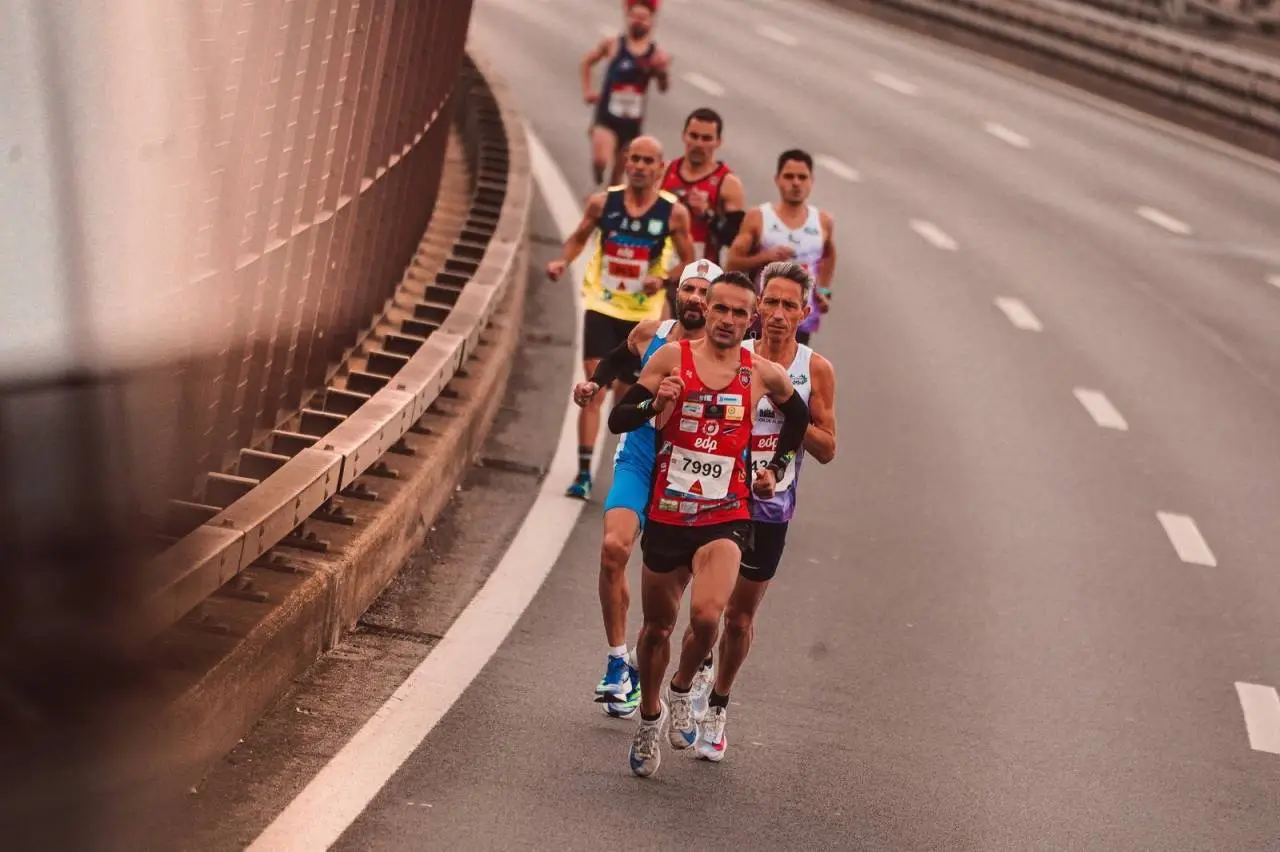 A group of male athletes competing in a city marathon, featuring diverse runners and dynamic movement.