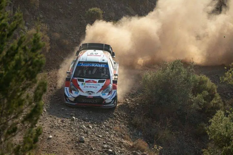 Thrilling rally car race on a dusty dirt road with dynamic motion and dramatic dust clouds.